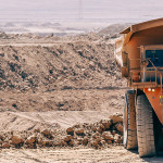 Image of a garbage truck and other machinery in the desert