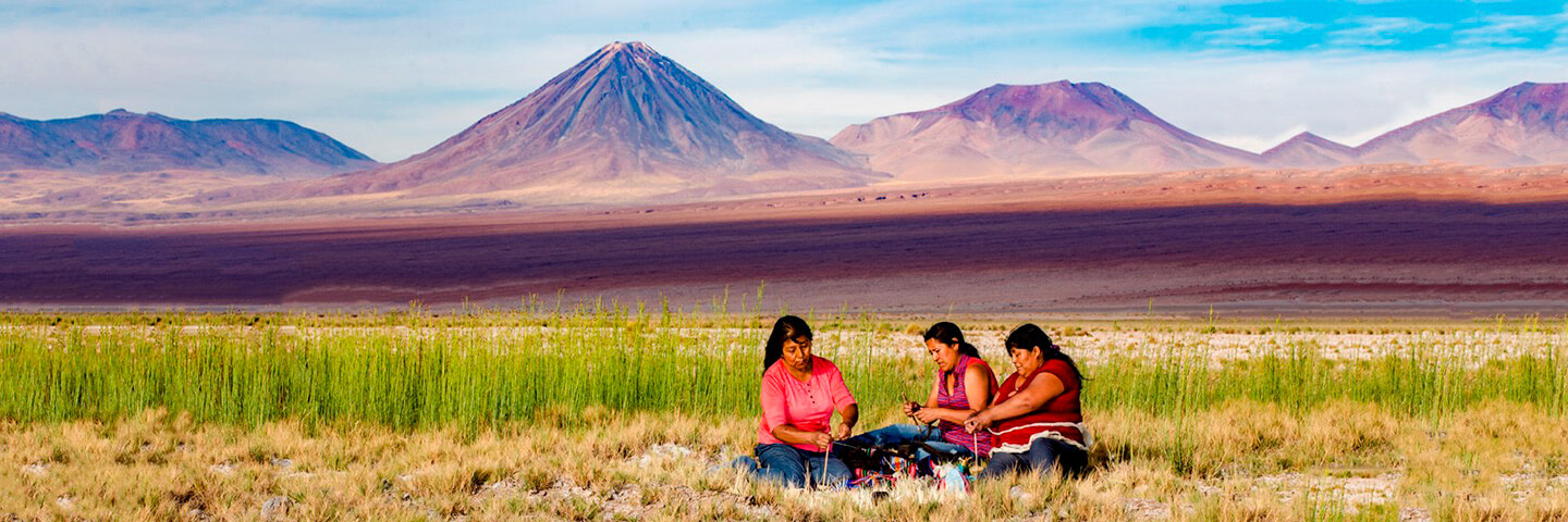 Imagen de tres mujeres tejiendo en el altiplano